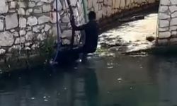 Polisi görünce dereye atladı