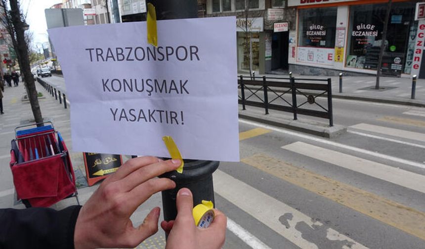 <p>Trabzonspor, geçen sezon yaşanan şampiyonluğun ardından bu sezon Süper Lig’de ve Avrupa maçlarında yaşadığı kayıplarla taraftarı hüsrana uğrattı. Bordo mavi renklere fanatikliğiyle bilinen Muhammet Yılmaz, takımın kötü gidişatını esprili bir şekilde protesto etti. Ramazan ayında oruç tutan taraftarların takıma sinirlenip küfür ederek oruçlarının bozulacağını düşünen Muhammet Yılmaz, kentin işlek caddelerine ‘Trabzonspor konuşmak yasaktır’ yazılı kağıtlar astı.</p>